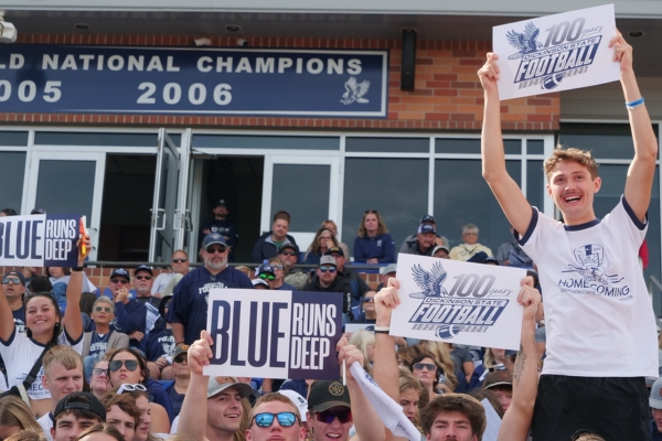 Student at a Football game holding signs