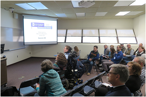 Audience members watching a presentation.