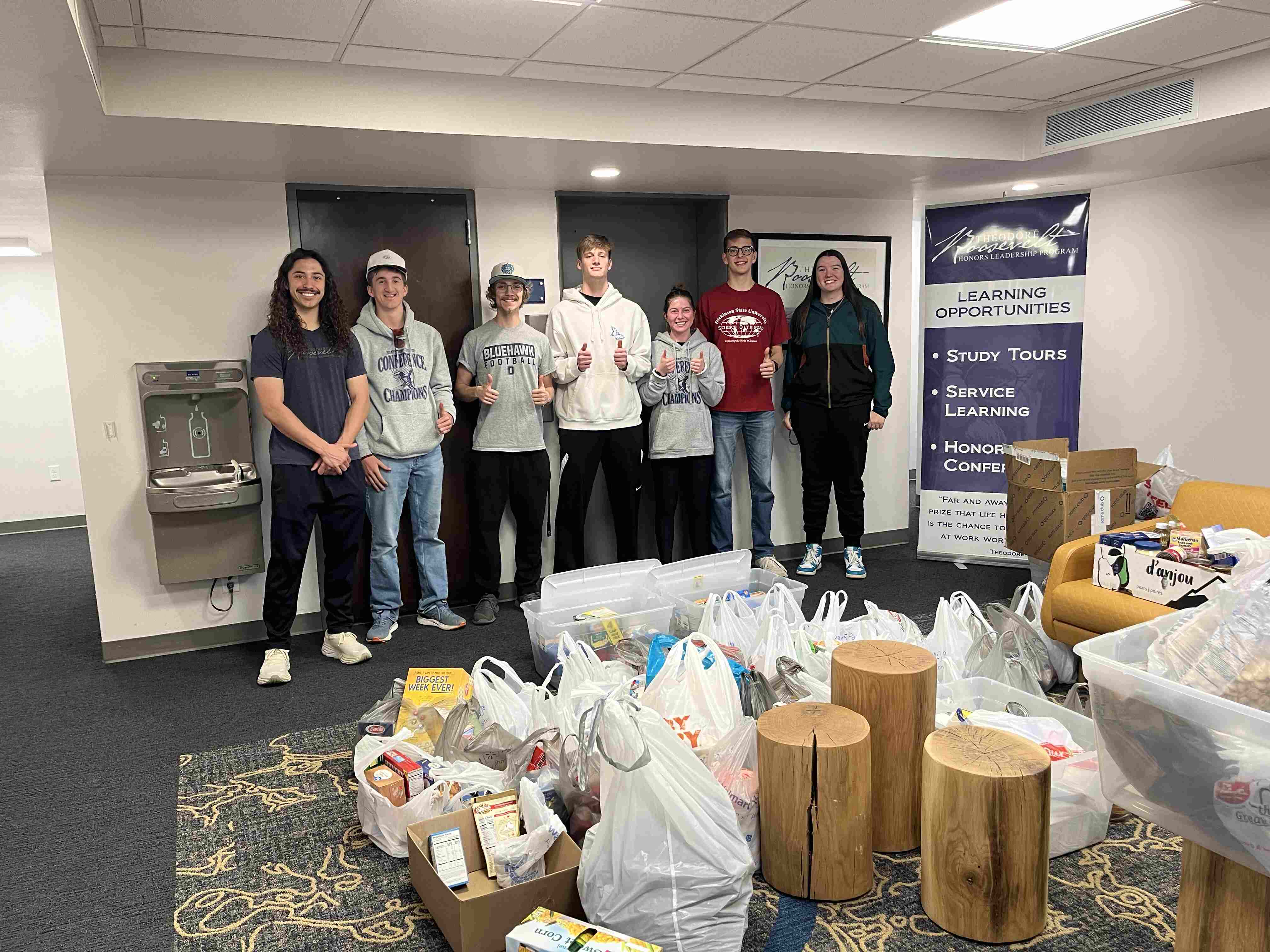 Theodore Roosevelt Honors Leadership students stand next to their collected items from their recent food drive.