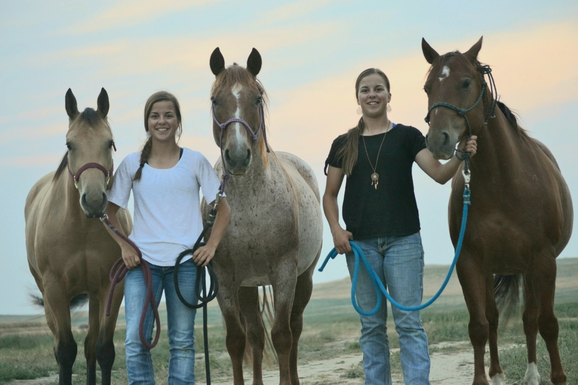 Heather and Hannah Labree posing with their horses for their senior photos.