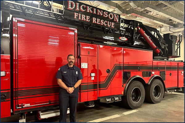 Fire Science Instructor, Jared Rhode, poses with Fire Engine.